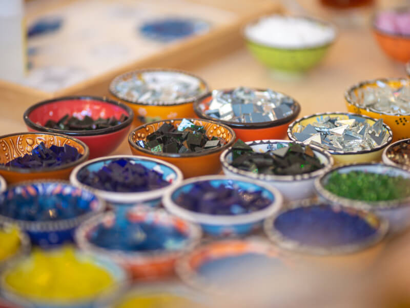 Close-up of small coloured glass pieces in bowls